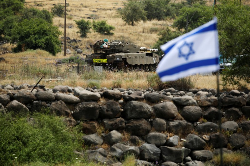An Israeli tank can be seen near the Israeli side of the border with Syria in the Israeli-occupied Golan Heights