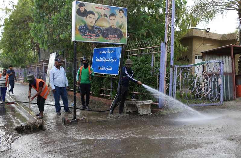 Municipality workers clean the site of a suicide attack in the predominantly Shi'ite Shula district, in northwest Baghdad