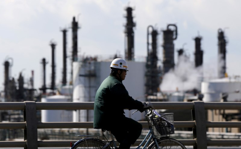 FILE PHOTO - A worker cycles near a factory at the Keihin industrial zone in Kawasaki, Japan