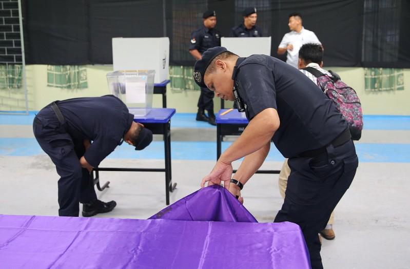 Policemen inspect a polling station before voting starts in the general election in Pekan