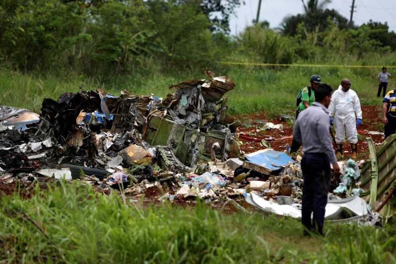 Rescue team members work on the wreckage of a Boeing 737 plane that crashed in the agricultural area of Boyeros