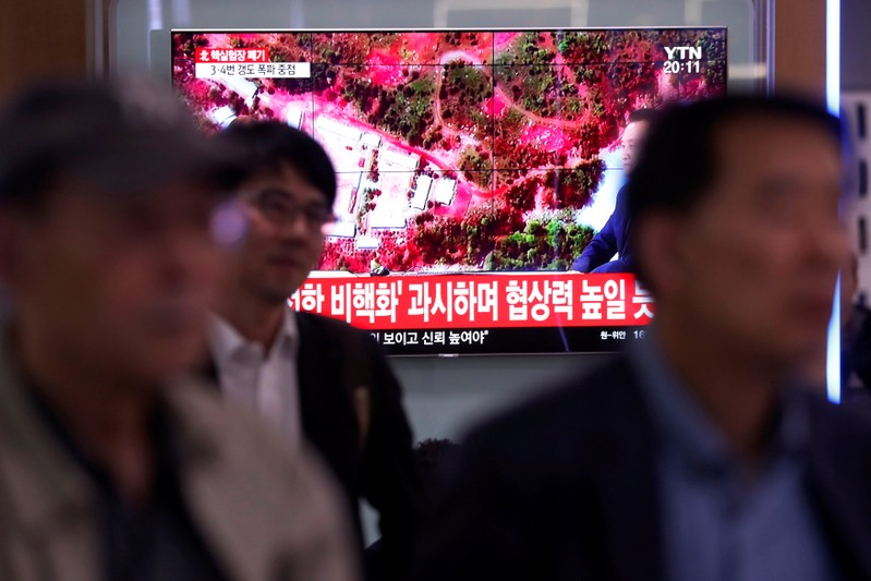 People watch a TV broadcasting a news report on the dismantling of the Punggye-ri nuclear testing site, in Seoul