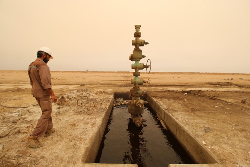 A worker walks past the oil well at the Sindbad oil field near the Iraqi-Iranian border in Basra