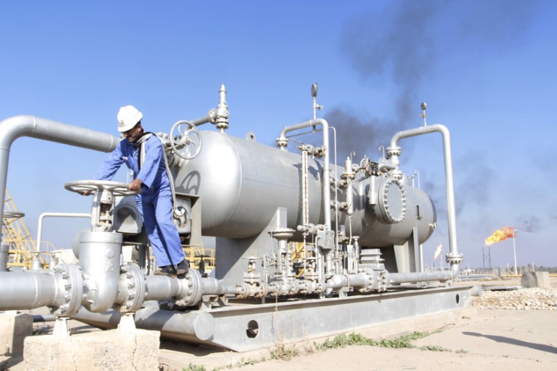 FILE PHOTO: A worker checks the valve of an oil pipe at Nahr Bin Umar oil field north of Basra