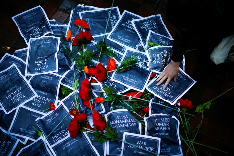 A demonstrator places a flyer on an improvised memorial with the names of Palestinians killed during clashes with Israeli troops on the Gaza-Israel border, during a protest demanding the freedom and dignity of Palestine, in the Manhattan borough of New Yor