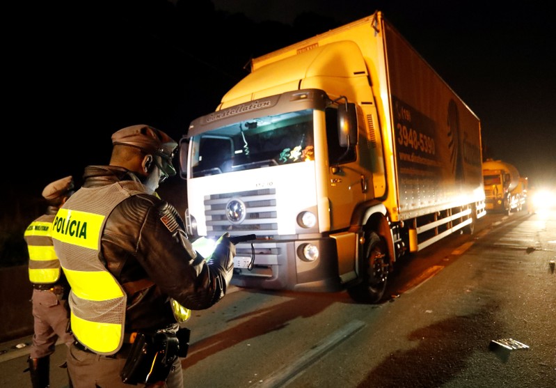 Police officers take position after they ordered truckers to clear the blocked SP-21 highway in Sao Bernardo do Campo