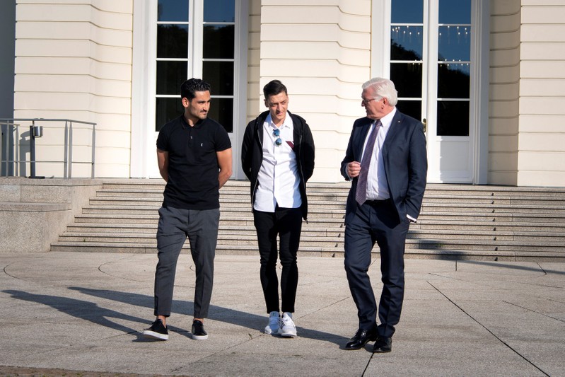 German President Steinmeier talks to national team players Gundogan and Ozil during a meeting at Bellevue Castle in Berlin