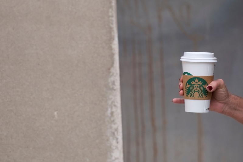 A woman walks through Center City clutching a hot Starbucks beverage, before more than 8,000 stores nationwide will close this afternoon for anti-bias training, in Philadelphia