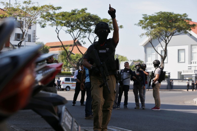 Anti-terror policemen stand guard following a bomb blast at police office in Surabaya