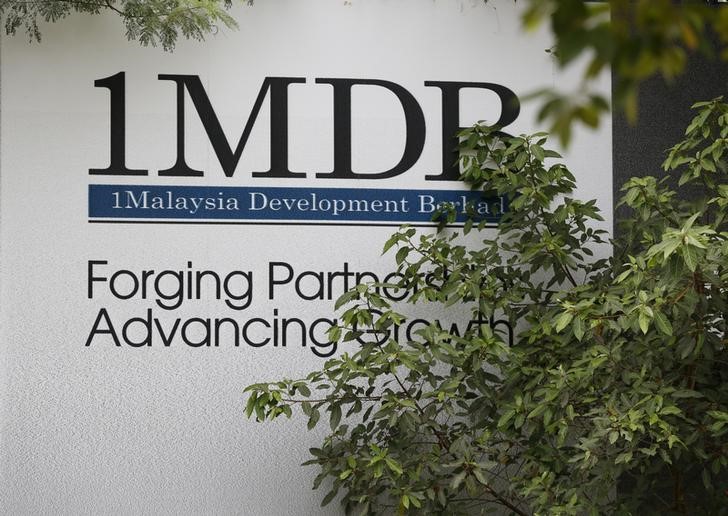Foliage partly covers a 1 Malaysia Development Berhad (1MDB) billboard at the funds flagship Tun Razak Exchange development in Kuala Lumpur, Malaysia