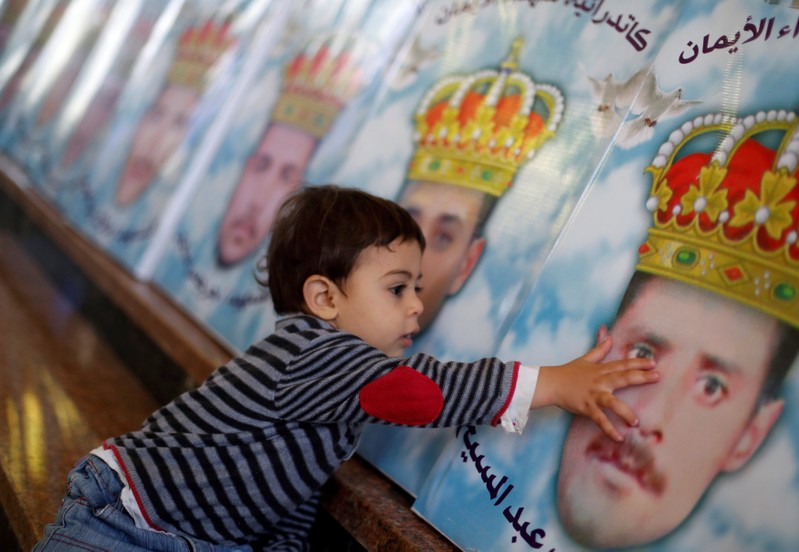 The son of one of the Egyptian Christians who were beheaded in Libya by Islamic State in 2015, touches his father's picture at a church in al-Our village south of Cairo