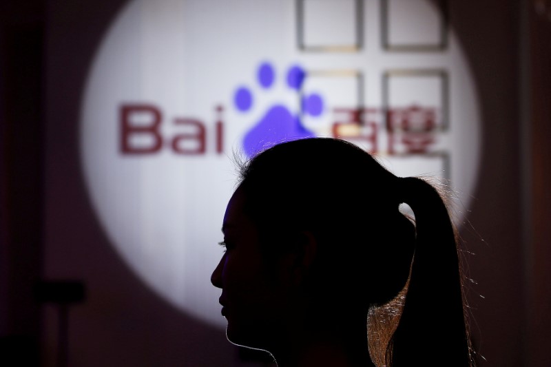 FILE PHOTO: A woman is silhouetted against the Baidu logo at a new product launch from Baidu, in Shanghai, China