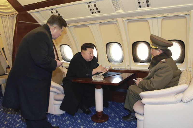 North Korean leader Kim Jong Un talks with officials onboard his personal plane