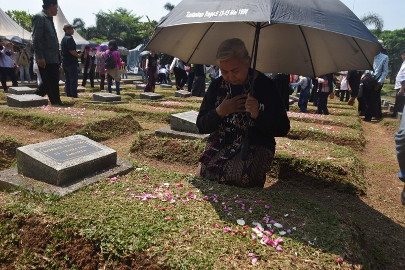 Maria Sanu, the mother of 16-year-old Stevanus Sanu, who died during the May 1998 riots, prays at a mass grave for victims of the tragedy during a 20th anniversary commemoration at Pondok Ranggon in Jakarta