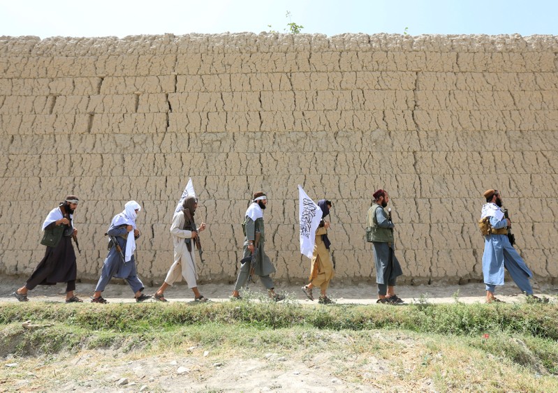 Taliban walk as they celebrate ceasefire in Ghanikhel district of Nangarhar province, Afghanistan