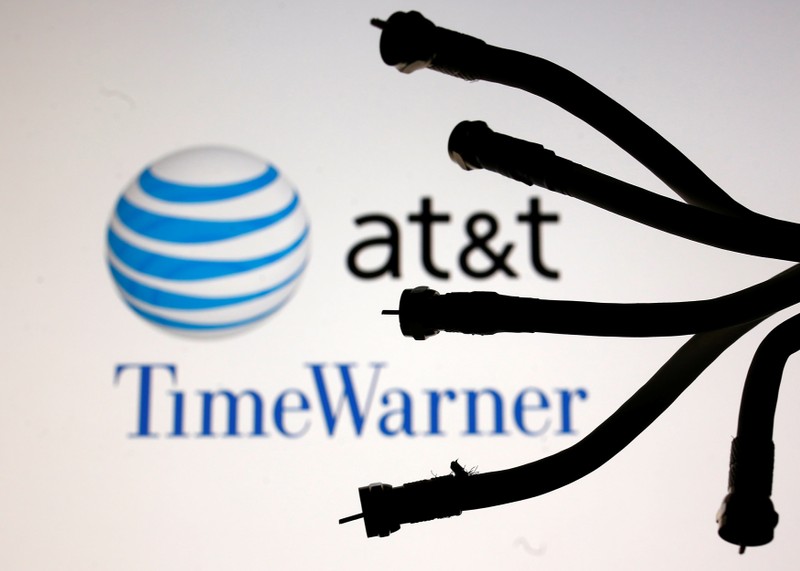 Coaxial TV Cables are seen in front of AT&T and Time Warner logos in this picture illustration