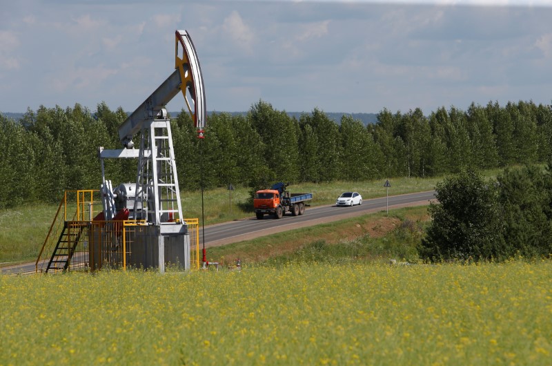 Cars drive past a pump jack at the Ashalchinskoye oil field owned by Russia's oil producer Tatneft near Almetyevsk, in the Republic of Tatarstan