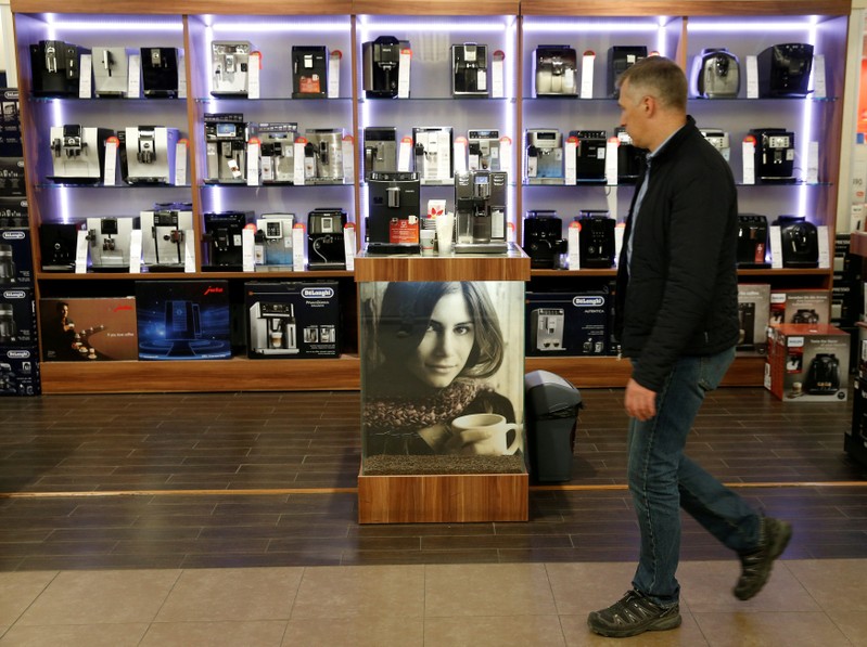 FILE PHOTO: Customer walks past display of coffee machines on sale in store of Russia's biggest electrical and white goods retailer M.video in Moscow