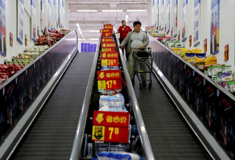 Shoppers ride on a travelator at a supermarket in Beijing