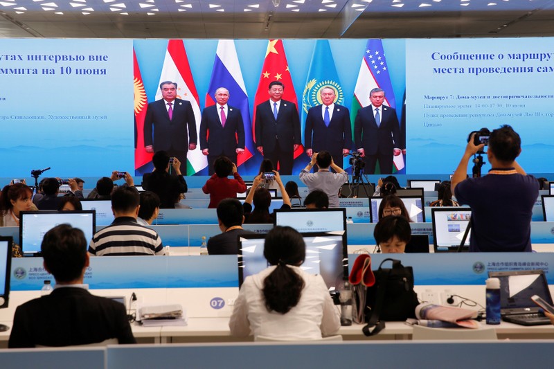 A TV screen shows a live broadcast of Chinese President Xi Jinping attending a group photo of Shanghai Cooperation Organization (SCO) summit at the media center, in Qingdao