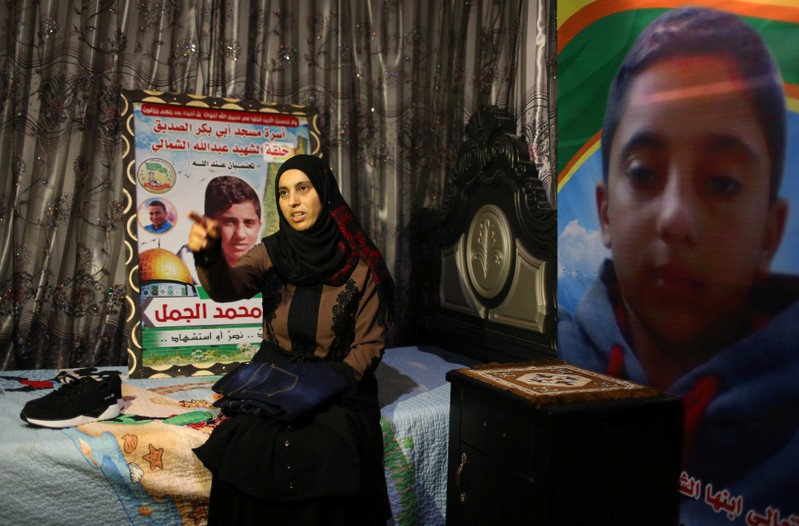 Mother of Palestinian Hiatham Al-Jamal, 15, who was killed during a protest at the Israel-Gaza border, gestures as she shows clothes he bought to wear during Eid al-Fitr holiday, in Rafah in the southern Gaza Strip