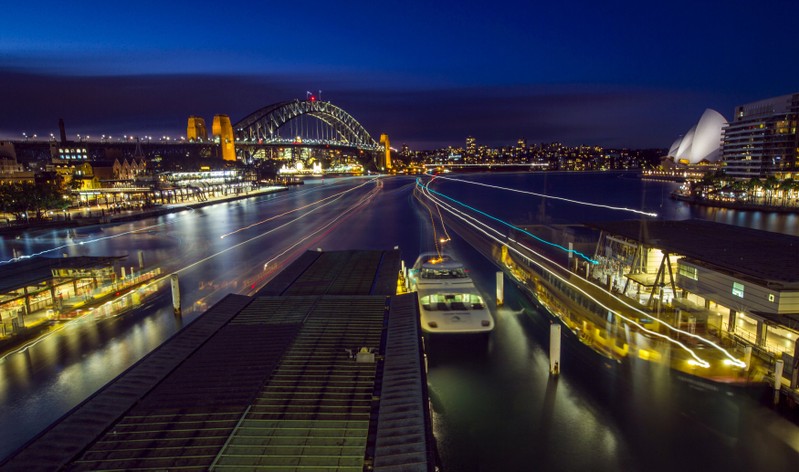 FILE PHOTO: Streaks of light from arriving ferries illuminate wharves at Sydney's Circular Quay terminal in this seven-minute-long time exposure at dusk