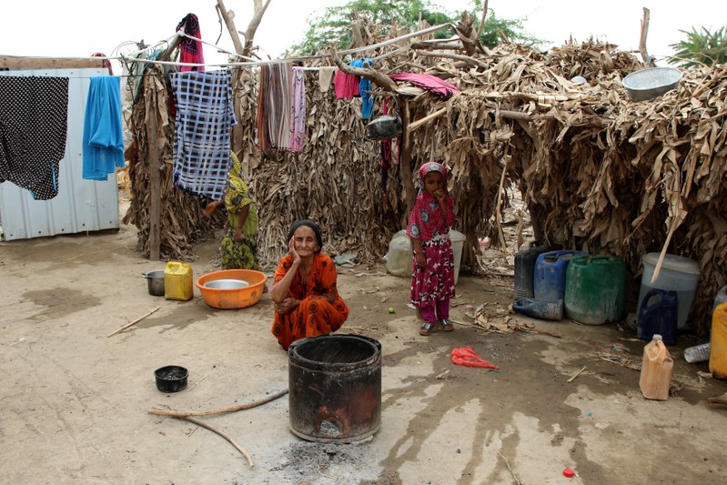 Woman displaced by the fighting in the Red Sea port city of Hodeidah sits near her hut at a camp for IDPs near Aden, Yemen