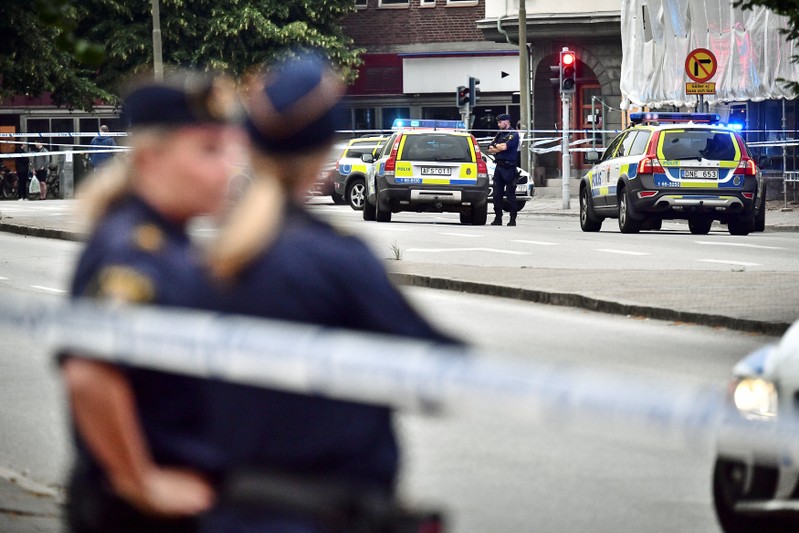 Police stand next to a cordon after a shooting on a street in central Malmo