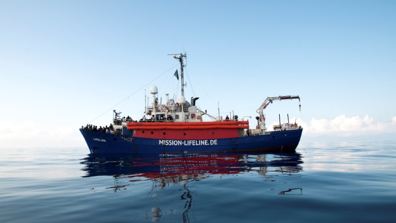 Migrants are seen on the deck of the Mission Lifeline rescue boat in the central Mediterranean Sea