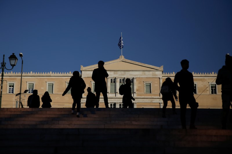 People walk in front of the parliament building in Athens