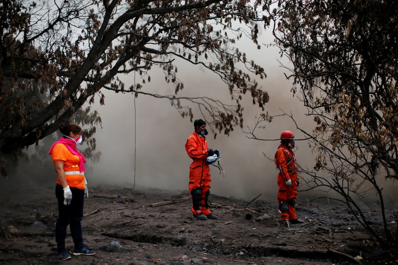 Eva Ascon, looks on next to rescue workers as they search for her rest of her family at the affected by the Fuego volcano at San Miguel Los Lotes