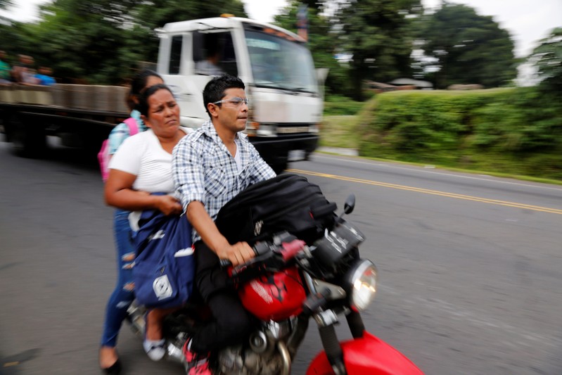 Displaced people travel on a motorcycle from an area affected by the eruption of Fuego volcano in Escuintla