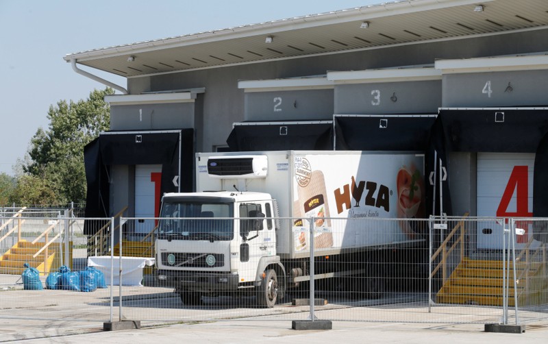 FILE PHOTO: A truck in which 71 dead migrants were found is parked at a customs building with refrigeration facilities in the village of Nickelsdorf