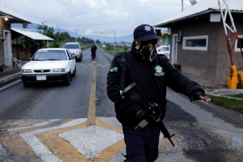 A member of the Community Police gestures to a driver at a checkpoint in the indigenous Purepecha town of Cheran