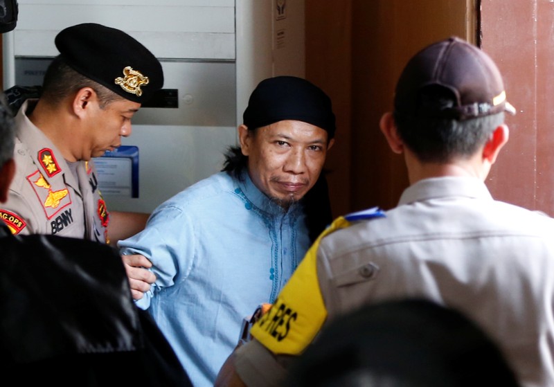 Islamic cleric Aman Abdurrahman leaves a court following his verdict in Jakarta