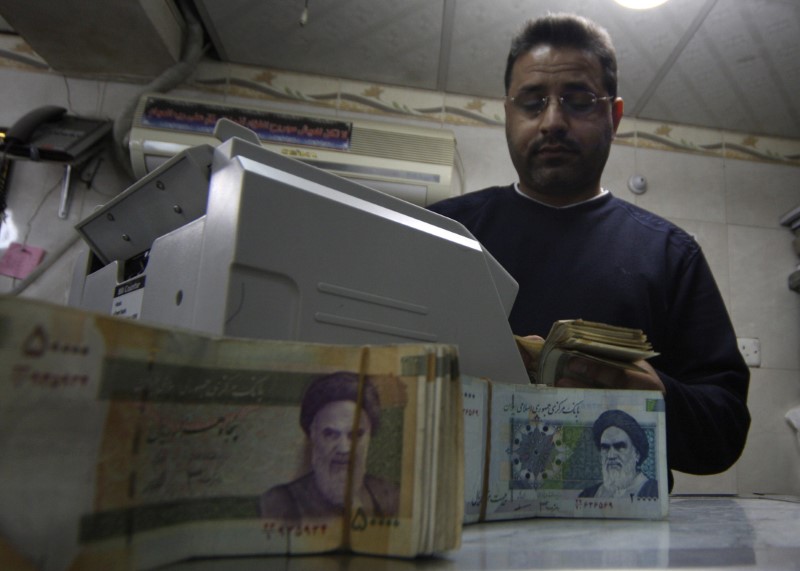 A man counts stacks of Iranian rials at a currency exchange shop in Kerbala