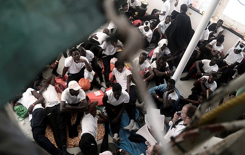 Migrants sit on the deck of the MV Aquarius, a search and rescue ship in the central Mediterranean Sea