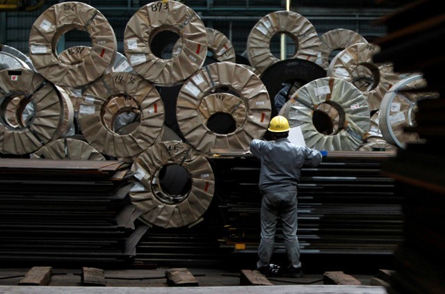 FILE PHOTO - A worker checks steel coils and steel sheets at a distribution warehouse in Urayasu, east of Tokyo