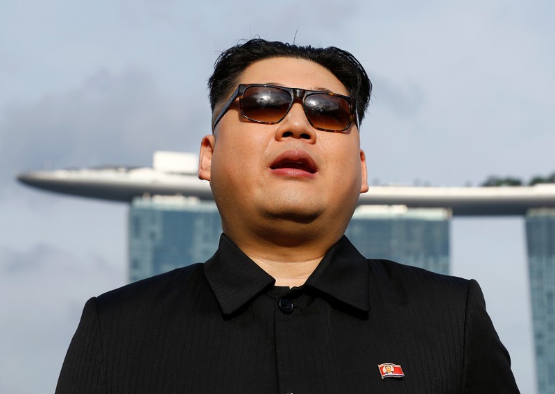 Howard, an Australian-Chinese impersonating North Korean leader Kim Jong Un, speaks with the Marina Bay Sands hotel in the background in Singapore