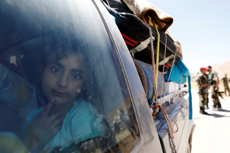 A Syrian refugee girl who left Lebanon looks through a window as she arrives in Qalamoun
