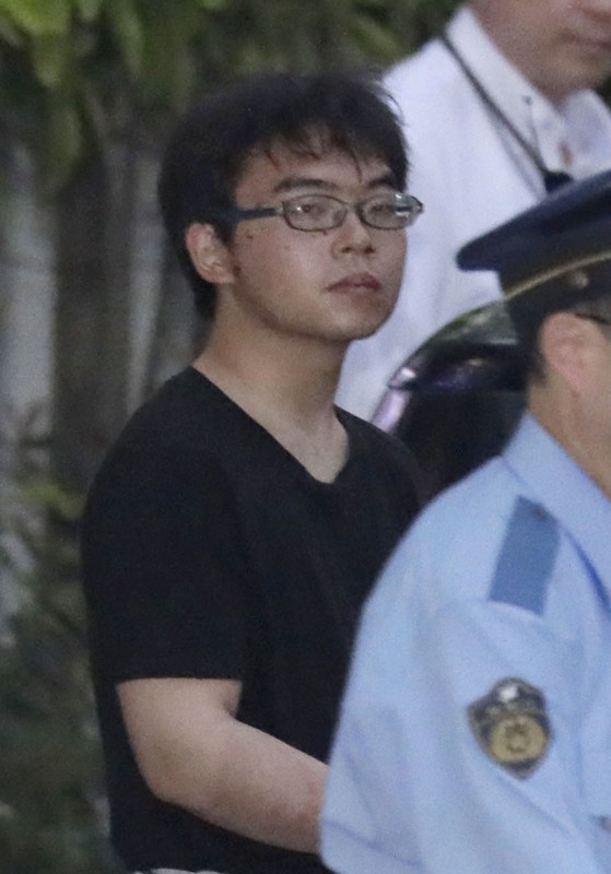 Ichiro Kojima, 22, a suspect in a stabbing incident inside a Japanese Shinkansen bullet train, leaves Odawara police station after being arrested