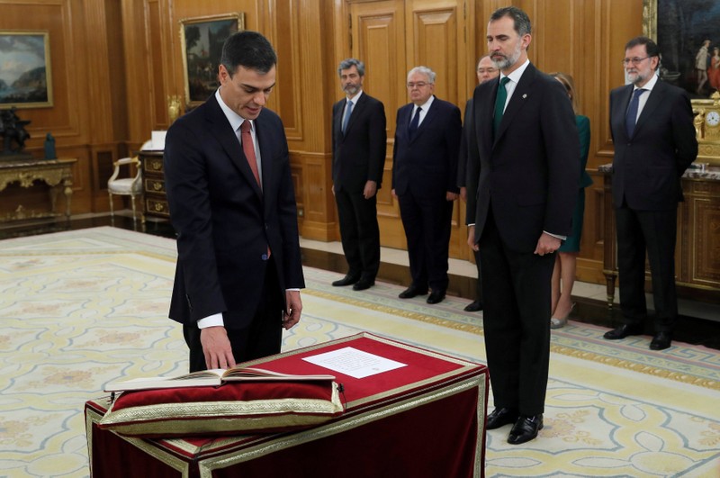 Spain's new Prime Minister and Socialist party (PSOE) leader Pedro Sanchez swears in next to King Felipe during a ceremony at the Zarzuela Palace in Madrid