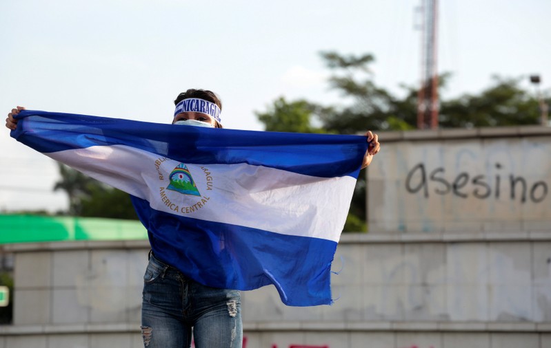 A demonstrator holds a national flag in support of teenagers who have died in recent protests against Nicaraguan President Daniel Ortega's government in Managua
