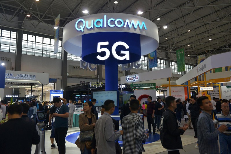 Visitors are seen by a booth of Qualcomm Inc at the China International Big Data Industry Expo in Guiyang
