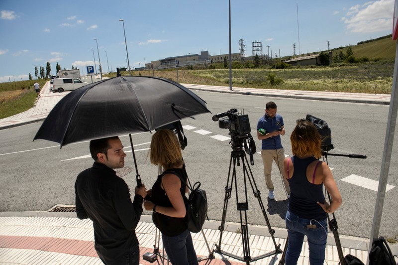 Journalists wait outside the prison where three of the five men cleared of gang rape of a teenager and convicted of a lesser crime of sexual abuse are due to leave jail after being granted provisional release in Pamplona
