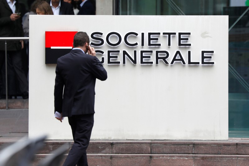 A man passes by the logo on the headquarters of French bank Societe Generale at the financial and business district of La Defense at Puteaux near Paris