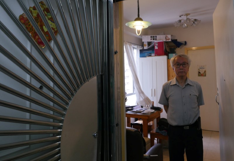 Ng Goon-lau poses inside his property where two suicides have taken place in Hong Kong