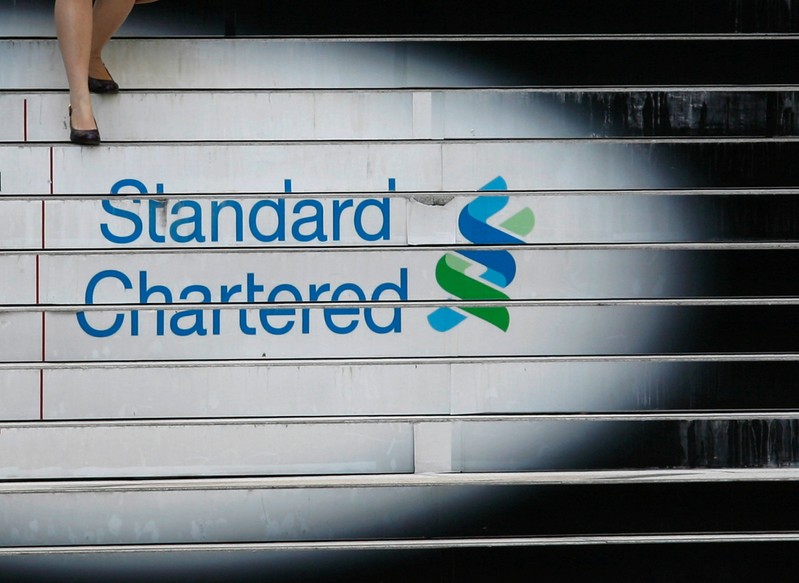 FILE PHOTO: A woman walks down the stairs of the Standard Chartered headquarters in Hong Kong