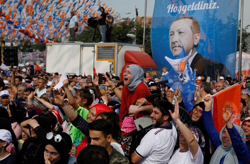 A girl in a wheelchair is raised in the air to watch Turkish President Tayyip Erdogan during an election rally in Istanbul