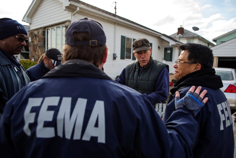 FILE PHOTO: Representatives from FEMA speak with resident of Staten Island borough neighborhood of New Dorp Beach about registering with the agency in New York